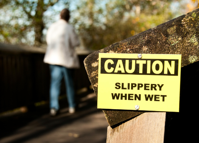 Yellow caution sign warning pedestrians, displayed to help prevent and reduce fall risks