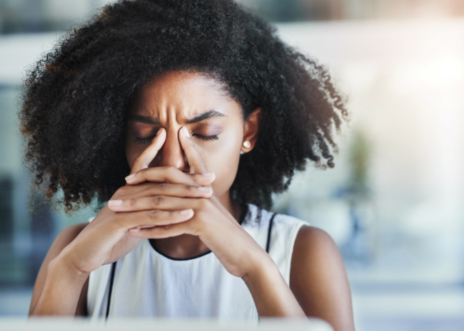 woman struggling with headache at work, needs physical therapy for headache