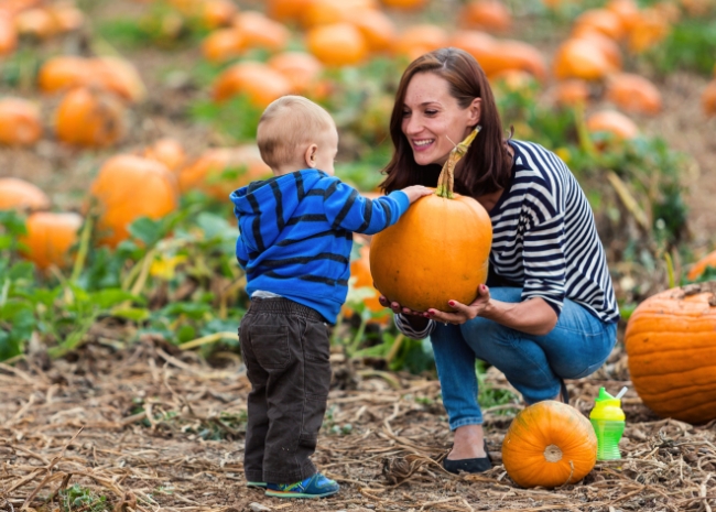 mom and child visiting pumpkin patch together